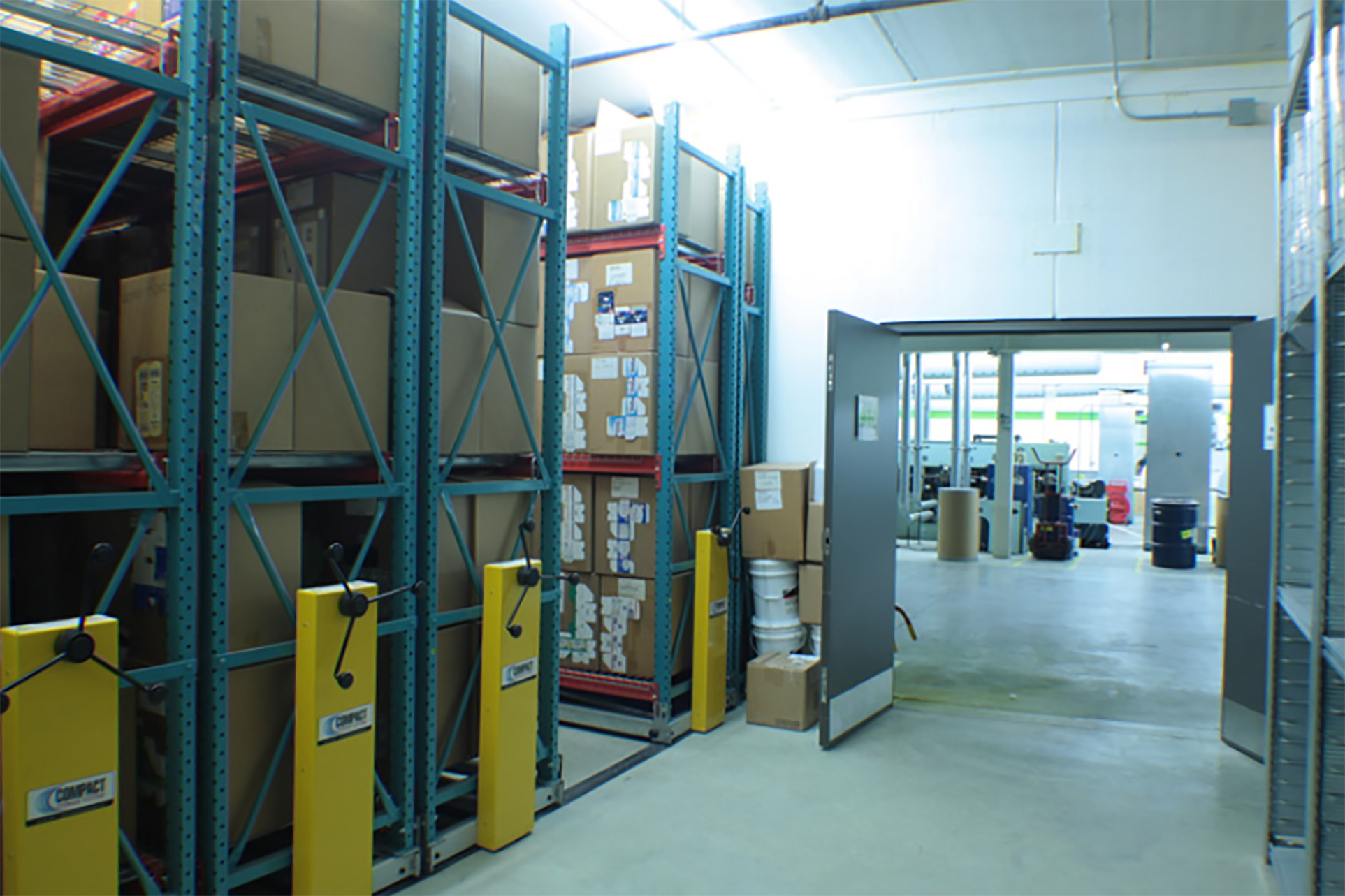 Printing supplies on mechanical assist compact warehouse racking system